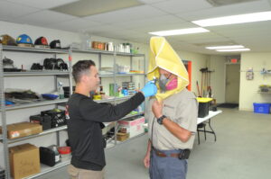 Photo of Kevin Hays undergoing fit testing of protective masks by employee Stephen Dollar